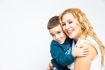 Portrait of Happy Loving Caucasian Mother With Her Son in Studio Indoors. Posing Against White Background.