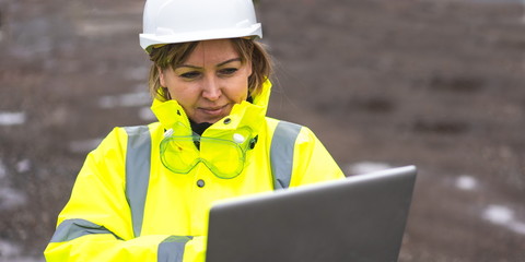 woman civil engineer close up. young woman using laptop on construction site. woman engineer developer holding laptop working Confident outdoors in construction site. Woman architect inspecting site. - obrazy, fototapety, plakaty