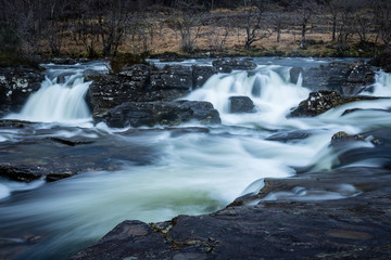 the waterfalls in Glen Orchy near Bridge of Orchy in the Argyll region of the highlands of Scotland during winter whilst the river is flowing fast from rainfall