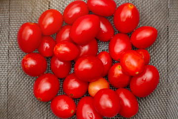 Fresh tomatoes in a plate on a wooden. Harvesting tomatoes. tomato variations on old wooden table. Delicious red tomatoes. Summer tray market agriculture farm full of organic vegetables. Top view