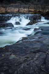 the waterfalls in Glen Orchy near Bridge of Orchy in the Argyll region of the highlands of Scotland during winter whilst the river is flowing fast from rainfall