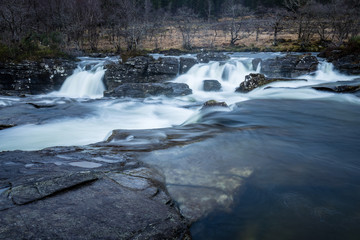 the waterfalls in Glen Orchy near Bridge of Orchy in the Argyll region of the highlands of Scotland during winter whilst the river is flowing fast from rainfall