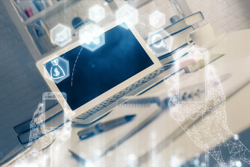 Computer on desktop in office with technology theme hologram. Multi exposure. Tech concept.