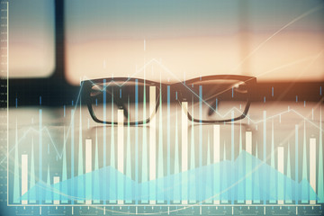 Financial graph hologram with glasses on the table background. Concept of business. Double exposure.