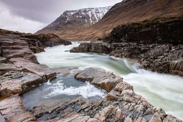 the river coupall waterfalls on rannoch moor showing buachaille etive mor in the background as the entrance to glencoe valley in winter