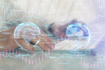 Double exposure of graph with man typing on computer in office on background. Concept of hard work.