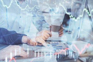 Multi exposure of chart with man typing on computer in office on background. Concept of hard work.
