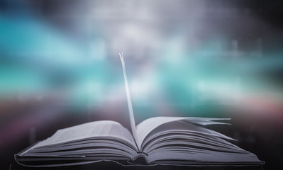 Imagine a picture book of an ancient book opened on a wooden table with a sparkling golden background. With magical power, magic, lightning around a glowing glowing book In the room of darkness