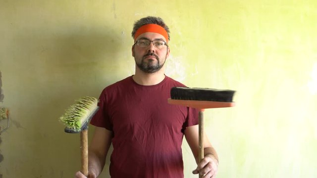 A funny man with a beard turns sexual brush. Standing at the wall