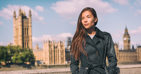 Lodnon Fashion Asian woman model walking on city street in front of parliament, UK travel autumn...