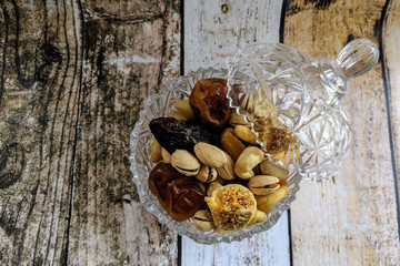 Healthy food: mix from dried fruits and nuts in bowl, old wooden background. Healthy eating concept.