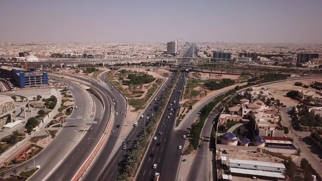 Flying over main highway towards busy intersection in Riyadh, infrastructure and modern urban landscape in Saudi Arabia's capital city