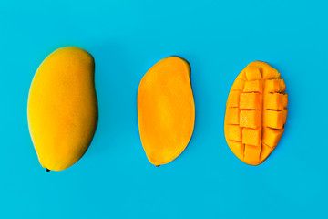 Fresh organic mango product, cutaway fruit. Blue background, isolated  top view. Space for copy.