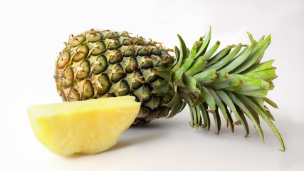 Close up view of whole and sliced ripe pineapple isolated on white background