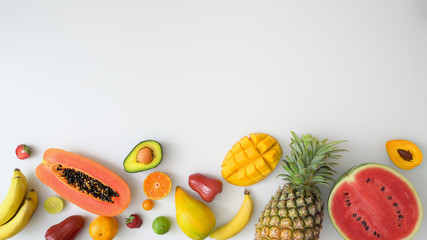 Top view of assortment of exotic fruits and copy space on white background