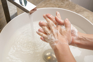 Hygiene. Cleaning hands with soap and water. Washing hands on sink. Preventing diseases by washing your hands.