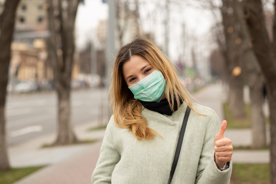 Woman In Medical Mask In A European City Showing Thumbs Up