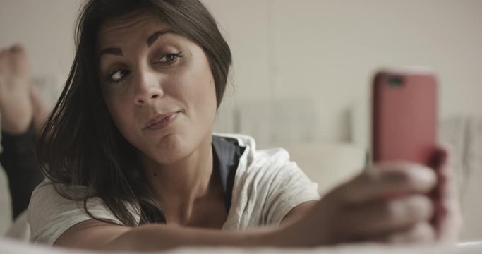 Young woman making funny faces while taking a selfie
