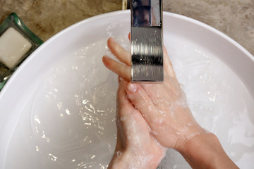 Fototapeta premium Hygiene. Cleaning hands with soap and water. Washing hands on sink. Preventing diseases by washing your hands.