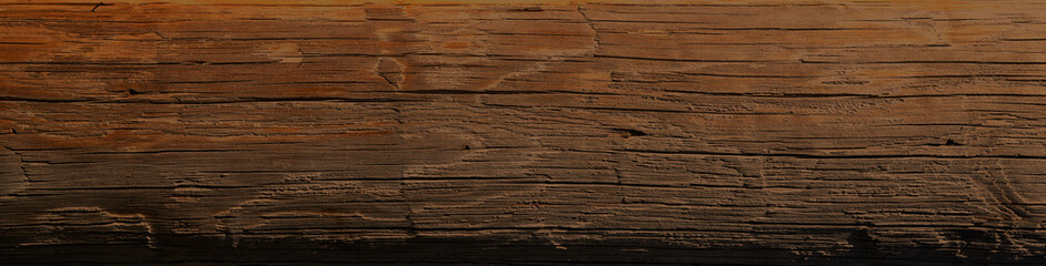 Dark stained reclaimed wood surface with aged boards lined up. Wooden floor planks with grain and texture.