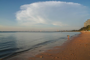 long sand beach with young woman wearing bikini in sunset time in holidays