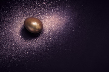 Golden egg and paint spray Galaxy on purple background. Abstract cosmos. Happy easter concept