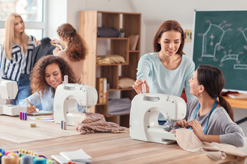 Young woman with teacher during tailor's class in atelier