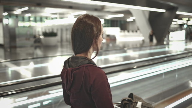 Young Girl with Luggage Walk on Airport Speedwalk. Side View of Woman Move to Boarding Gate. Transit Passenger, Traveler on Travelator. Modern International Terminal.