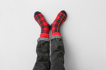 Legs of little child in socks and jeans on light background