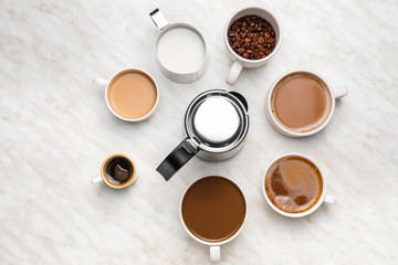 Composition with cups of different coffee on light background