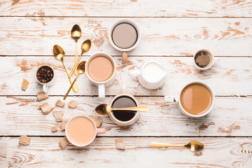 Composition with cups of different coffee on light background
