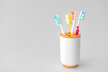 Holder with tooth brushes on light background