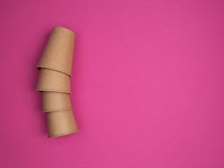 Eco Kraft paper utensils on a pink background.