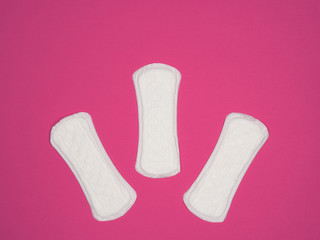 Women's sanitary pads on a pink background.