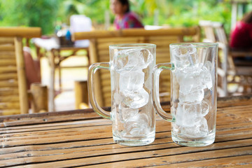 Two transparent glasses with ice in a summer cafe. Glasses with ice without water