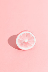 Slice of lemon with bones. Summer, youth, freshness concept. Funny pink monochrome citrus. Vertical format.
