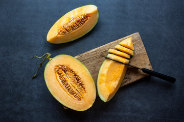 Fresh Juicy honeydew melon sliced on dark gray background .healthy food.hami melon.  L 由 litchima 提供
