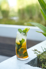 A fresh orange mocktail is served on a wooden table with leaf ornaments.