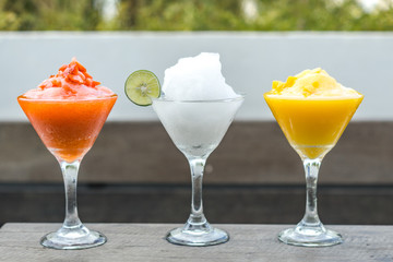 Frost drinks of various flavors are served on a wooden table on the roof top.