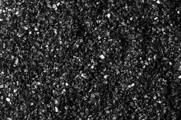 Background of black sand. Fine glass chips. Macro shooting.