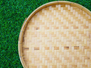 bamboo weave trays container for Thai food isolated on green grass background.