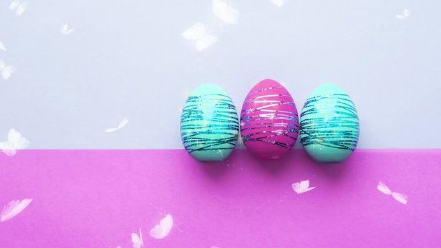 Easter eggs on a bright colored background, white butterflies flying around. The concept of Easter.