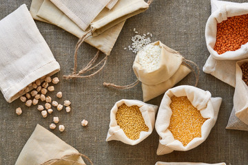 Various grains in cotton bags on a textile background