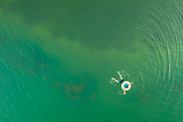 A person swimming at the beach and taking a aerial view