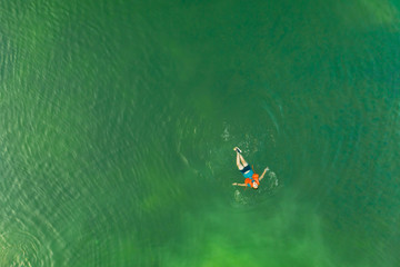 A person swimming at the beach and taking a aerial view