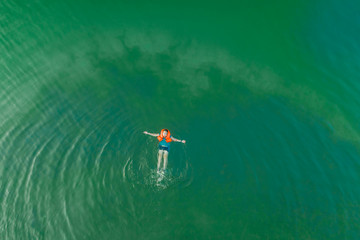 A person swimming at the beach and taking a aerial view