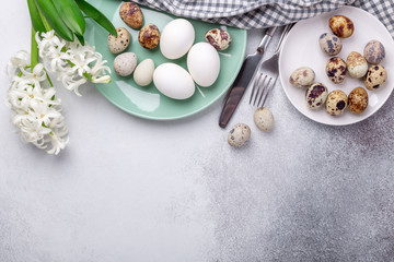 Obraz na płótnie Canvas Beautiful Easter table setting in Scandinavian style. Green mint plate, eggs, hyacinth and silver cutlery on stone background. Copy space. Top view