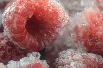 Raspberry red ripe frozen berry with ice crystals background