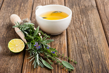 cup of herbal tea and sage, lavender, thyme, iceland lichen herb leaves on scoop
