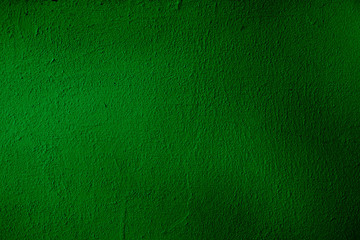 Dark green shiny background. Dark green uneven color. A sheet of dark green crumpled paper with natural light. Fragment of a crumpled sheet of dark-colored paper with highlights